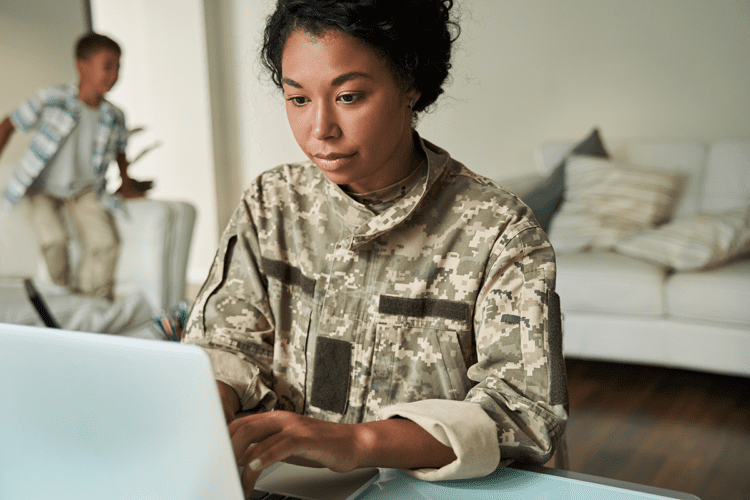 veteran woman sitting at a desk looking at a computer